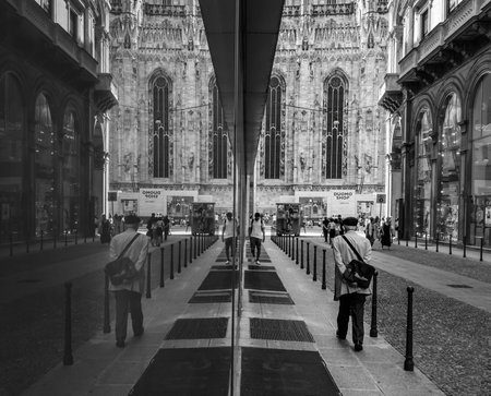 Milan/Italy - July 12, 2016: Street scene and Milan Cathedral reflection in the window of a store in Milan, famous tourist destination in Lombardy, Italy.のeditorial素材