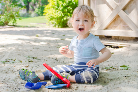 Cute little child standing on the grass in the parkの写真素材