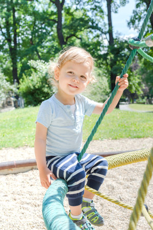 Cute little child standing on the grass in the parkの写真素材