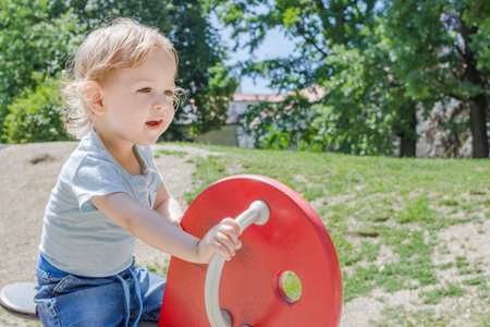 Cute little child and his mother playing in the parkの写真素材