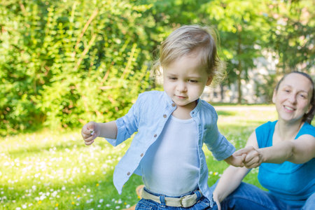 Cute little child and his mother playing in the parkの写真素材
