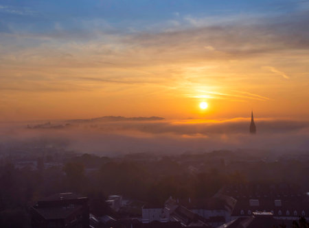 Cityscape of Graz with Church of the Sacred Heart of Jesus and historic buildings, in Graz, Styria region, Austria, at sunrise. Beautiful foggy morning over the city of Graz, in autumnの写真素材