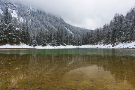 Amazing winter landscape with snowy mountains and clear waters of Green lake (Gruner see), famous tourist destination in Styria region, Austriaの写真素材