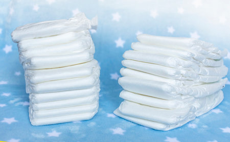 Stack of white disposable diapers for little babies on nice blue background with stars. Selective focusの写真素材