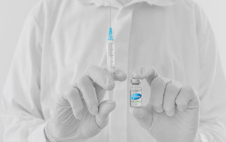 Graz,Austria-26.01.2021: Doctor hands holding a vaccine bottle and syringe, beginning of mass...