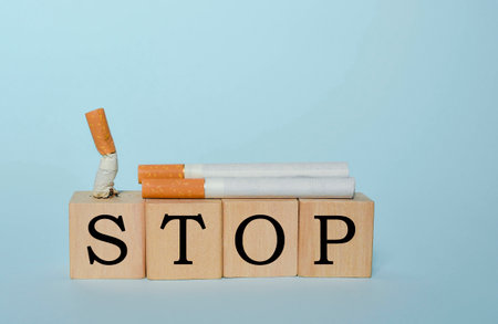 Stop smoking concept, cigarettes and STOP text on wooden blocks. World No Tobacco Day on May 31 concept. Selective focusの写真素材