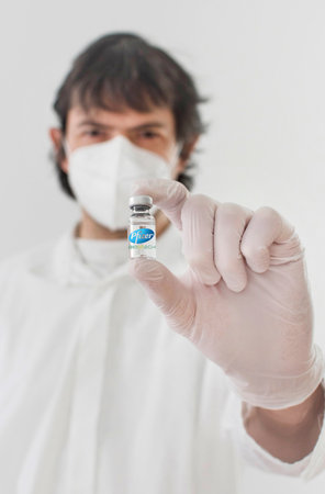 Graz,Austria-26.01.2021: Doctor holding a vaccine bottle and syringe, beginning of mass vaccination with the Pfizer-BioNTech COVID-19 vaccine, coronavirus world immunization conceptのeditorial素材