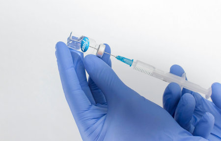 Graz,Austria-26.01.2021: Doctor hands holding a vaccine bottle and syringe, beginning of mass vaccination with the Pfizer-BioNTech COVID-19 vaccine, coronavirus world immunization conceptのeditorial素材