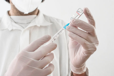 Graz,Austria-26.01.2021: Doctor holding a vaccine bottle and syringe, beginning of mass vaccination with the Moderna COVID-19 vaccine, coronavirus world immunization conceptのeditorial素材