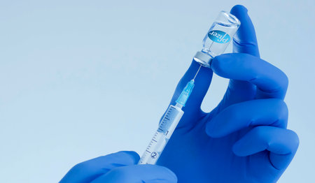 Graz,Austria-26.01.2021: Doctor hands holding a vaccine bottle and syringe, beginning of mass vaccination with the Pfizer-BioNTech COVID-19 vaccine, coronavirus world immunization conceptのeditorial素材