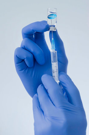 Graz,Austria-26.01.2021: Doctor hands holding a vaccine bottle and syringe, beginning of mass vaccination with the Pfizer-BioNTech COVID-19 vaccine, coronavirus world immunization conceptのeditorial素材