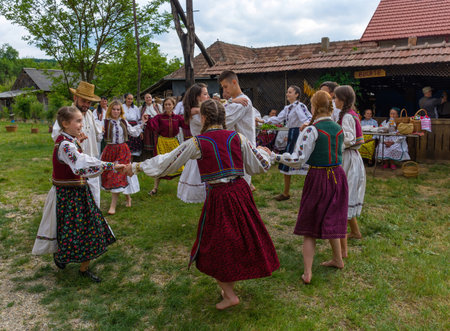 Salaj, Transylvania, Romania- May 15, 2018: young people dressed in Romanian folk costumes having fun and dancing at a traditional country fair in Marin village, Salaj countyのeditorial素材