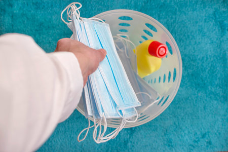 Man hands throwing medical masks in the trash, end of quarantine and disease concept. Selective focusの写真素材
