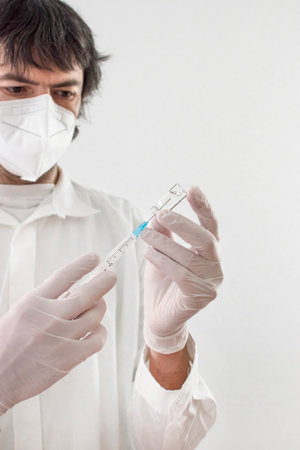 Doctor holding a vaccine bottle and syringe, beginning of worldwide mass vaccination for , influenza or flu, world immunization concept. Selective focusの写真素材