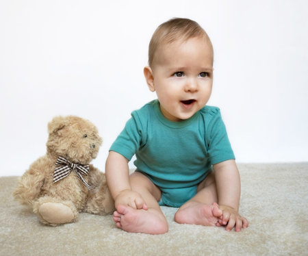 Sweet little baby boy portrait with his little teddy bear on white backgroundの写真素材