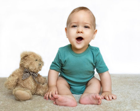 Sweet little baby boy portrait with his little teddy bear on white background