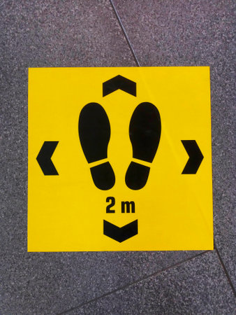 Keep distance sign printed on the floor, safety sticker on ground during outbreak, social distancing in a public area to prevent spreading virus disease infectionの写真素材