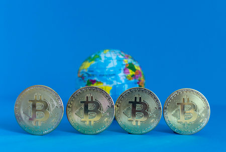 Bitcoin BTC crypto currency gold coins and Earth globe, worldwide new virtual money concept. Mining or blockchain technologyの写真素材