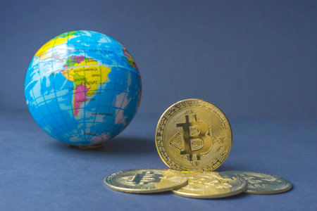 Bitcoin BTC crypto currency gold coins and Earth globe, worldwide new virtual money concept. Mining or blockchain technologyの写真素材