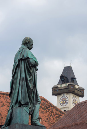Detail of Erzherzog Johann fountain at Hauptplatz (main square) and the famous clock tower (Grazer Uhrturm) in the background, in Graz, Styria region, Austria.の写真素材