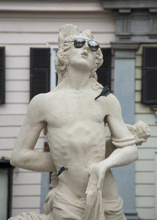 Funny detail of a statue of the Trinity Column with sun glasses in Karmeliter square (Karmeliterplatz), Graz, Steiermark, Styria Region, Austria.のeditorial素材