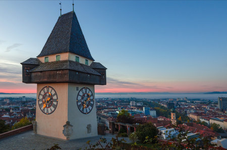 Cityscape of Graz and the famous clock tower (Grazer Uhrturm) on Shlossberg hill, Graz, Styria region, Austria, in autumn, at sunriseのeditorial素材
