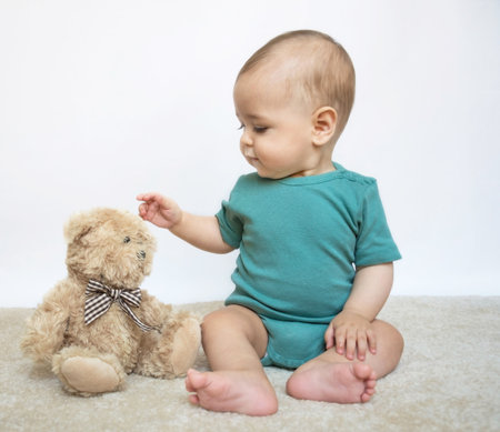 Sweet little baby boy portrait with his little teddy bear on white backgroundの写真素材