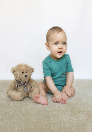 Sweet little baby boy portrait with his little teddy bear on white backgroundの写真素材