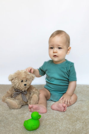 Sweet little baby boy portrait with his little teddy bear on white backgroundの写真素材