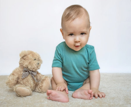 Sweet little baby boy portrait with his little teddy bear on white backgroundの写真素材