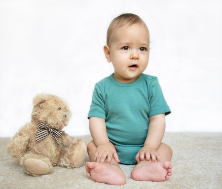 Sweet little baby boy portrait with his little teddy bear on white backgroundの写真素材