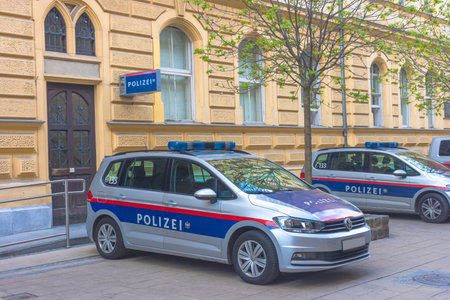 Austrian federal police cars parked on the street in front of the police headquarters in the old city center of Graz, Austriaのeditorial素材