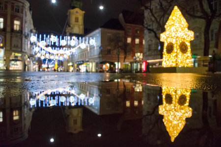 Blurred Christmas lights with famous Clock Tower on Herrengasse street, at night, in the city center of Graz, Steiermark, Austria.の写真素材