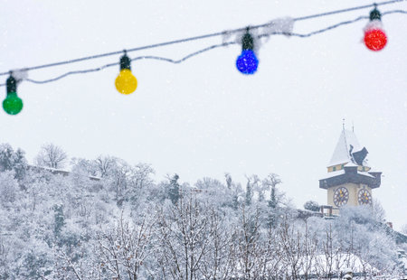 Heavy snow and the famous clock tower on Schlossberg hill, in Graz, Steiermark region, Austria. Selective focusの写真素材