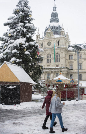 Graz, Austria-December 09, 2021: People walking through heavy snow in Main square Hauptplatz with Town Hall building in the city center of Graz, Steiermark, Austria, in winter dayのeditorial素材