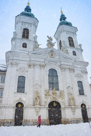 Graz, Austria - December 09, 2021: People in front of the beautiful Mariahilfer church on heavy snow, in Graz, Steiermark, Austria, in winterのeditorial素材