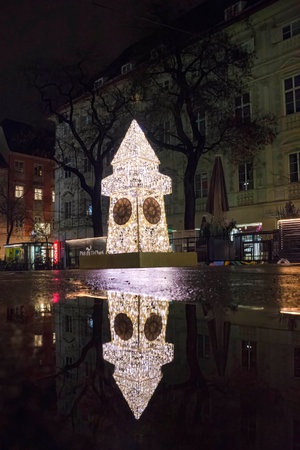 Graz, Austria-December 02, 2021: Beautiful Christmas decorations with famous Clock Tower on Herrengasse street, at night, in the city center of Graz, Steiermark, Austria. Selective focusのeditorial素材
