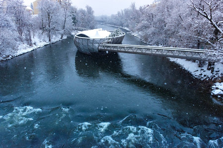 Mur river with Murinsel bridge in Graz, Steiermark region, Austria, with snow, in winterの写真素材