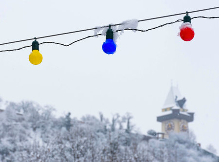 The famous clock tower on Schlossberg hill, in Graz, Steiermark region, Austria, with snow, in winter. Selective focusの写真素材
