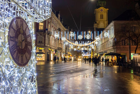 Graz, Austria-December 02, 2021: Beautiful Christmas decorations with famous Clock Tower on Herrengasse street, at night, in the city center of Graz, Steiermark, Austria. Selective focusのeditorial素材