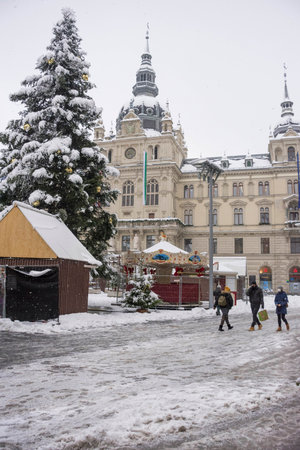Graz, Austria-December 09, 2021: People walking through snow in Main square Hauptplatz with Town Hall building in the city center of Graz, Steiermark, Austria, in winter dayのeditorial素材