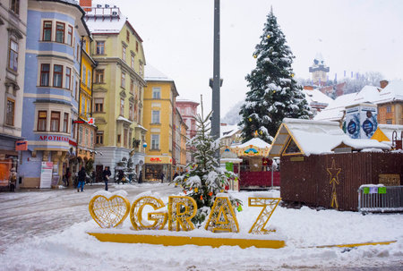 Graz, Austria-December 09, 2021: People walking through snow in Main square Hauptplatz, in the city center of Graz, Steiermark, Austria, in beautiful winter dayのeditorial素材