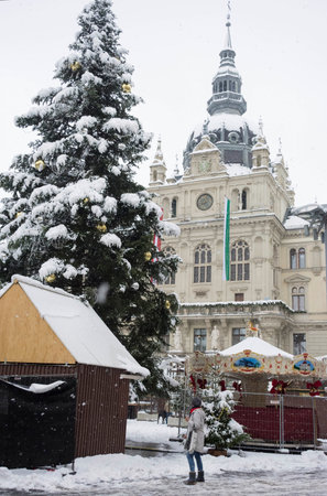 Graz, Austria-December 09, 2021: People walking through snow in Main square Hauptplatz with Town Hall building in the city center of Graz, Steiermark, Austria, in winter dayのeditorial素材