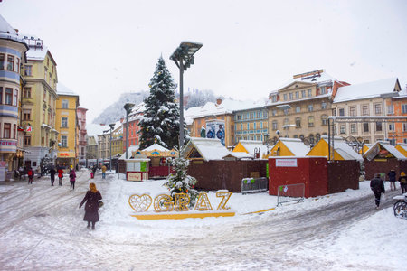Graz, Austria-December 09, 2021: People walking through snow in Main square Hauptplatz, in the city center of Graz, Steiermark, Austria, in beautiful winter dayのeditorial素材