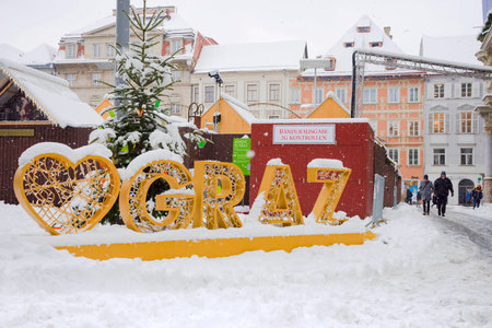 Graz, Austria-December 09, 2021: People walking through snow in Main square Hauptplatz, in the city center of Graz, Steiermark, Austria, in beautiful winter dayのeditorial素材