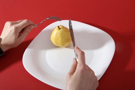 Eating a tasty yellow pear.の写真素材