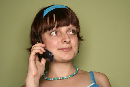 young woman calling by cellular phone. Isolated over greenの写真素材