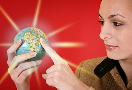 Globe in a girl's hands. Isolated on redの写真素材
