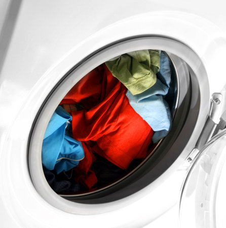 Colorful shirt and trousers in a white laundry.の写真素材