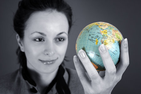 Globe in a girl's hands. Isolated on greyの写真素材
